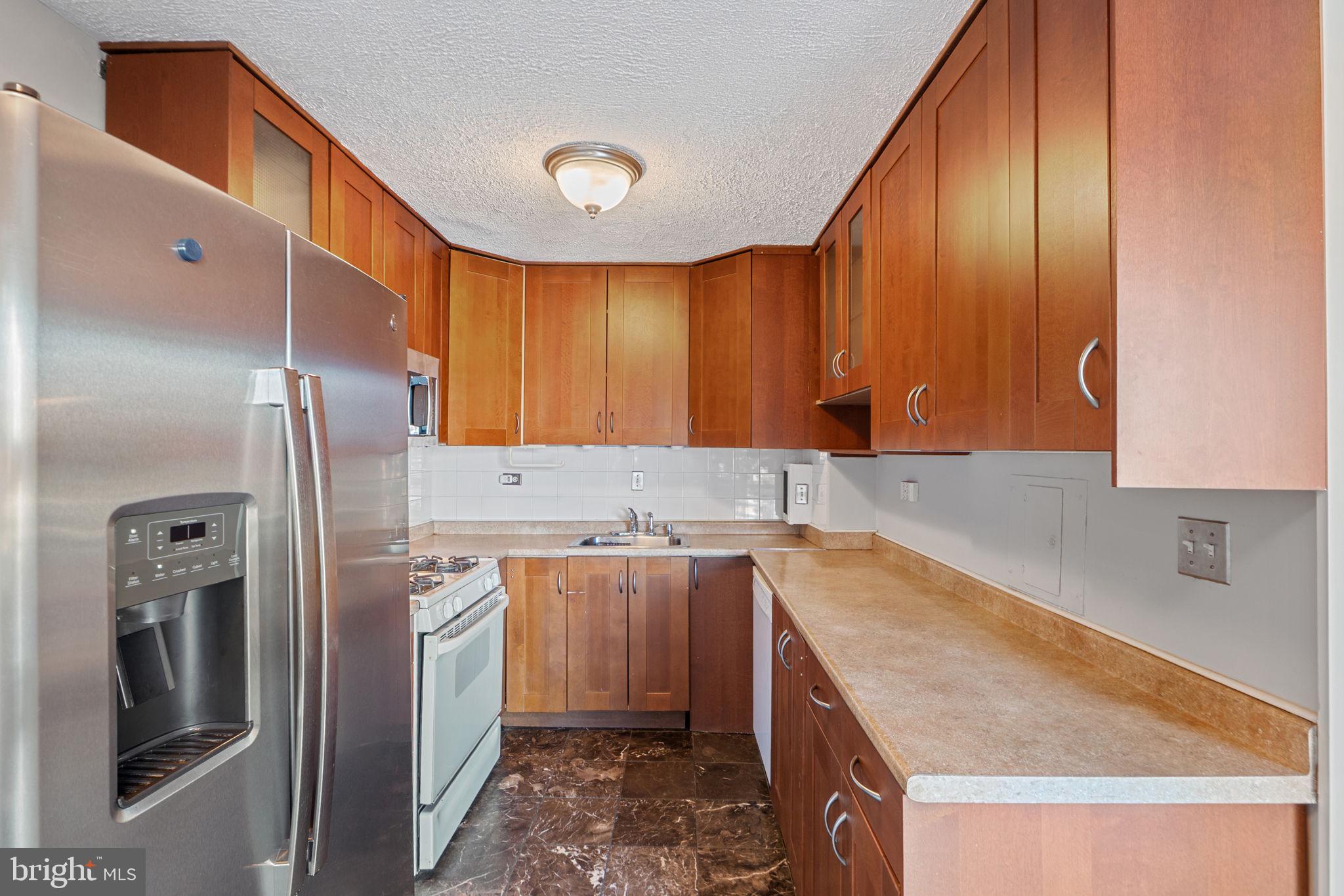 431 North Armistead Street, Unit 211 Alexandria, VA 22312 - Photo 17 of 27 a kitchen with a sink a refrigerator and cabinets