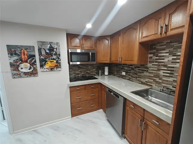 a view of kitchen with refrigerator stove and wooden floor