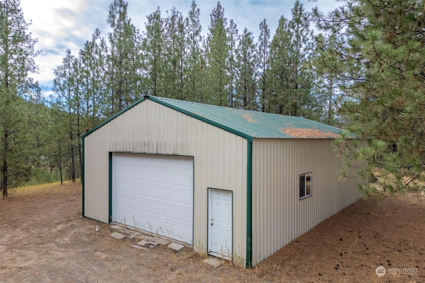 745 D Hall Road Colville, WA 99114 - Photo 17 of 27 a view of a house with a garage and yard