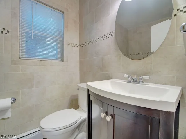 a bathroom with a toilet a sink and mirror