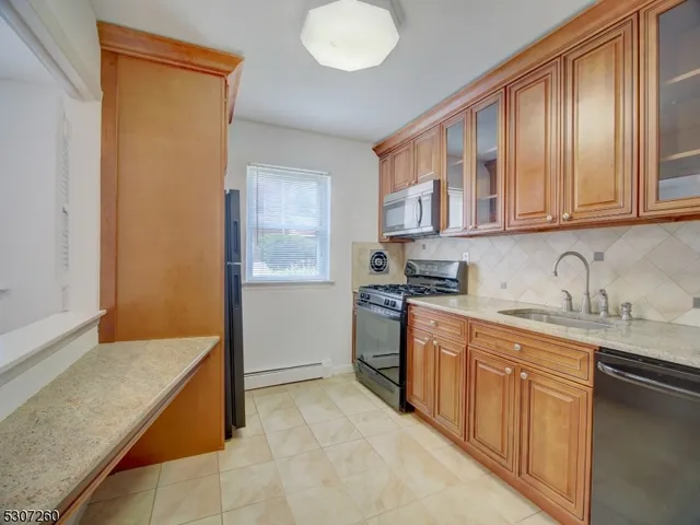 a kitchen with granite countertop a sink stove and cabinets