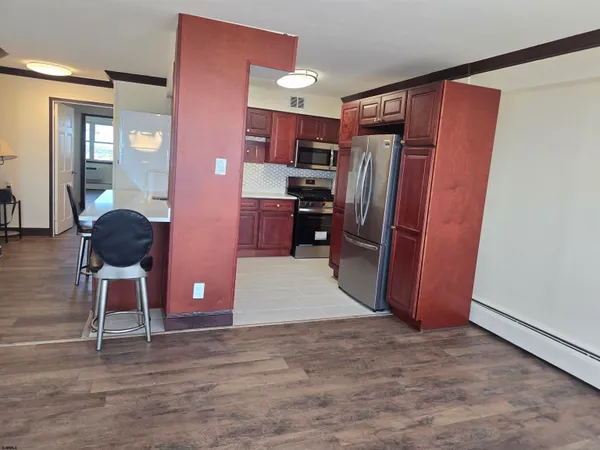 a kitchen with stainless steel appliances kitchen island granite countertop a refrigerator and a sink