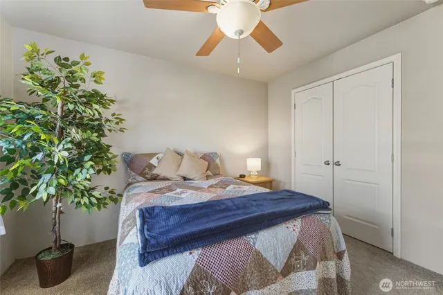 a bedroom with a bed and a potted plant