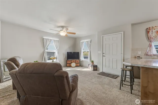 a living room with furniture a flat screen tv and a table