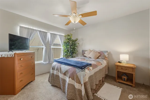 a bedroom with a bed and a flat tv screen on dresser