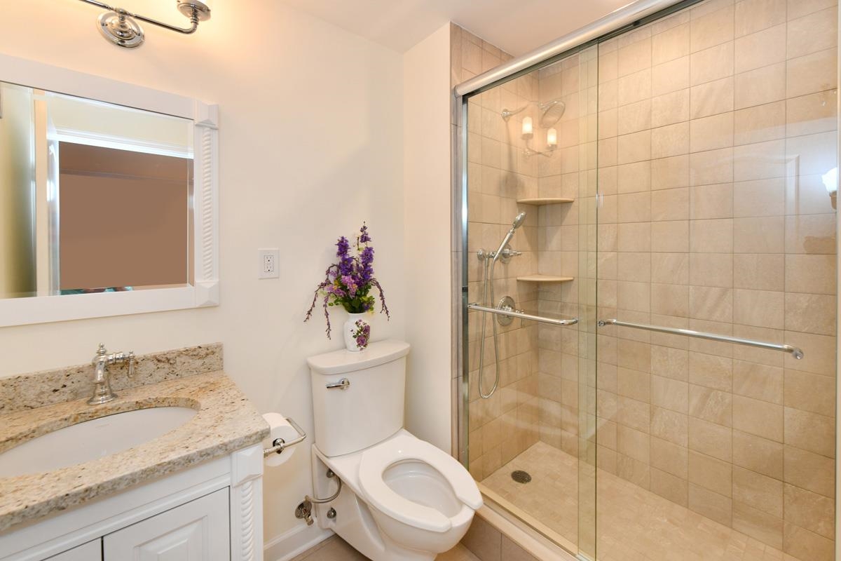 7000 Boulevard East, Unit 43H Guttenberg, NJ 07093 - Photo 6 of 8 a bathroom with a granite countertop sink toilet a mirror and shower