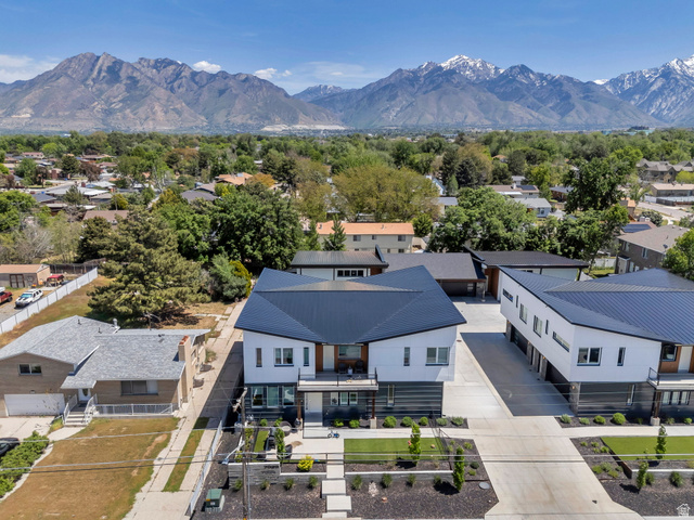 7045 South 300 East Midvale, UT 84047 - Photo 3 of 49 Modern multi-level residence featuring a dark metal roof and white and gray facade