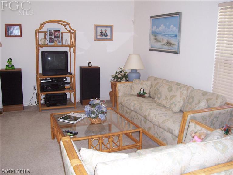 15669 Spring Line Lane Fort Myers, FL 33905 - Photo 5 of 13 a living room with furniture a flat screen tv and a wall clock