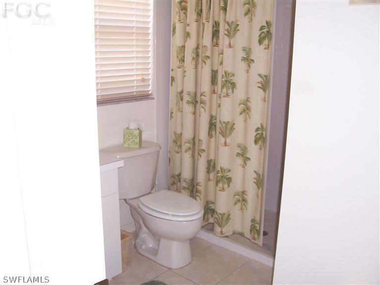 15669 Spring Line Lane Fort Myers, FL 33905 - Photo 10 of 13 a white toilet sitting next to a shower curtain