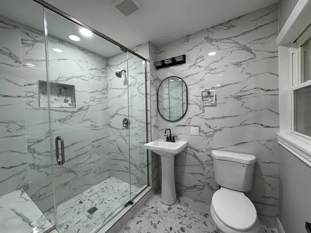 a bathroom with a toilet sink and mirror