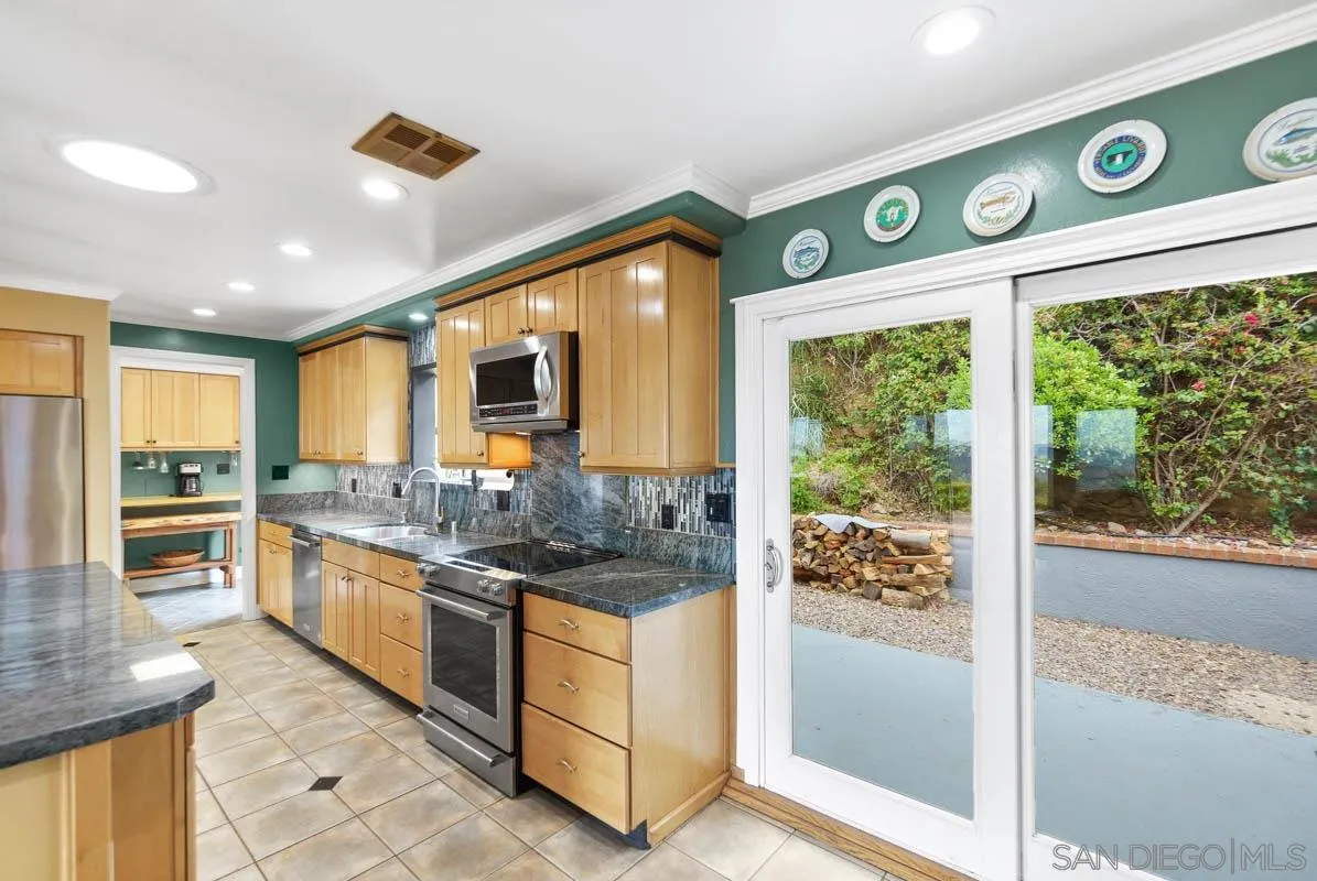 14770 High Valley Road Poway, CA 92064 - Photo 13 of 32 a kitchen with stainless steel appliances granite countertop a stove and a large window