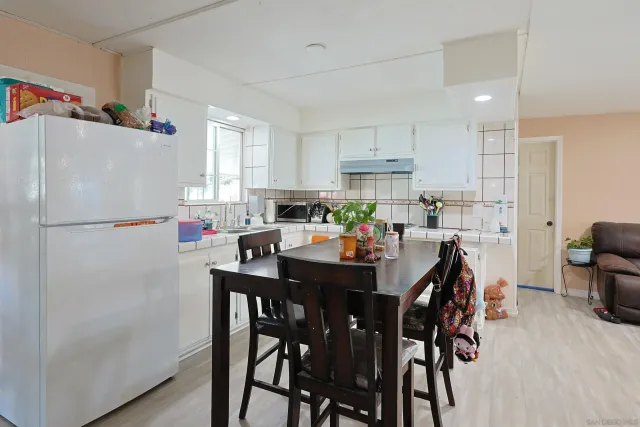 a kitchen with a sink white cabinets and wooden floor