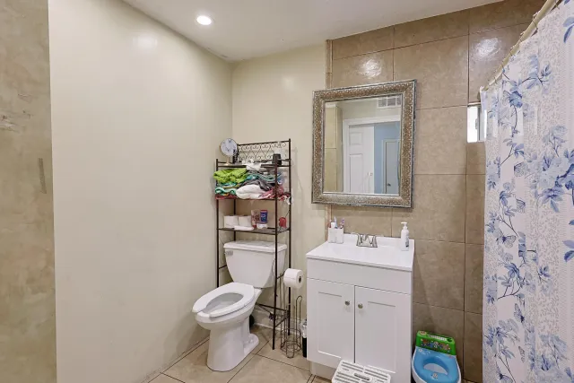 a bathroom with a toilet sink vanity and mirror