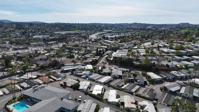 an aerial view of a city with lots of residential buildings and ocean view