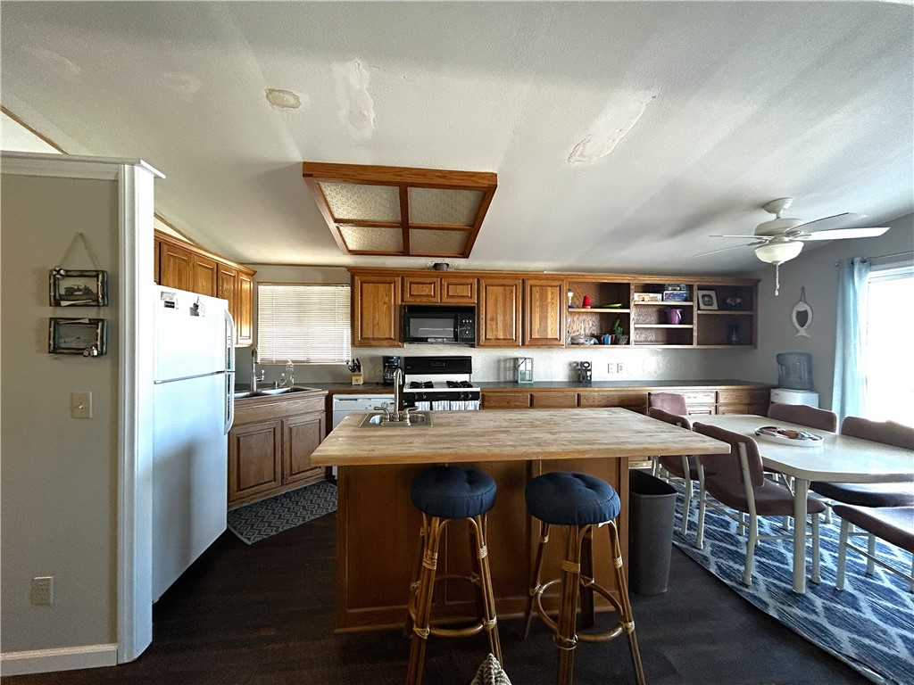 65 2nd Street Needles, CA 92363 - Photo 5 of 14 a kitchen with stainless steel appliances a table chairs refrigerator and cabinets