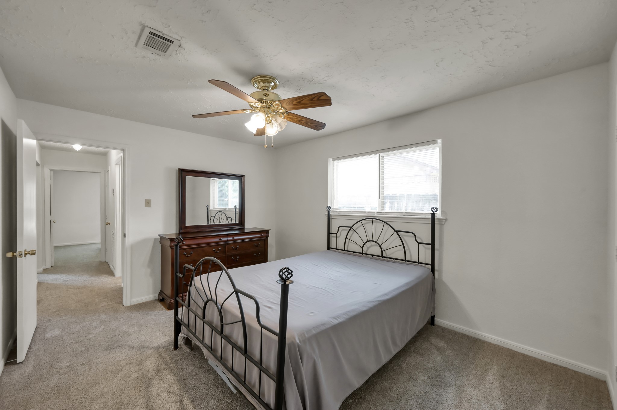 4314 Enchantedgate Drive Spring, TX 77373 - Photo 33 of 47 Bright guest bedroom with a large window, featuring a ceiling fan and carpeted flooring. The walls are painted white, creating a clean and airy feel.