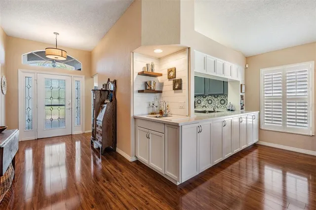 a view of kitchen with stainless steel appliances granite countertop a lot of counter space and wooden floor