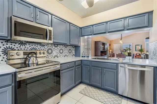 a kitchen with stainless steel appliances a sink stove and cabinets