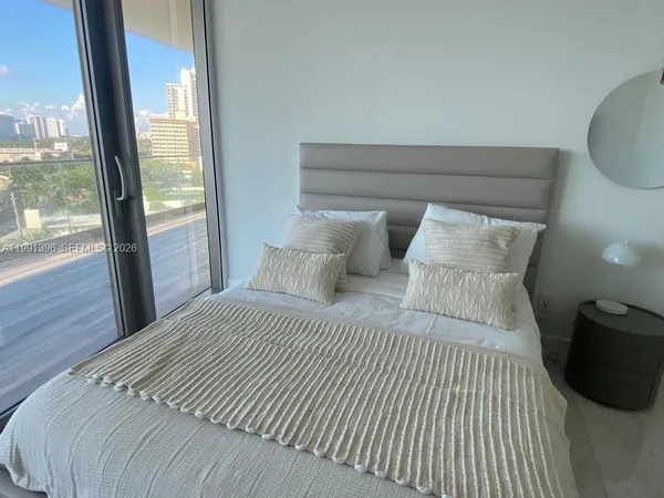 a bedroom with a bed and a large window