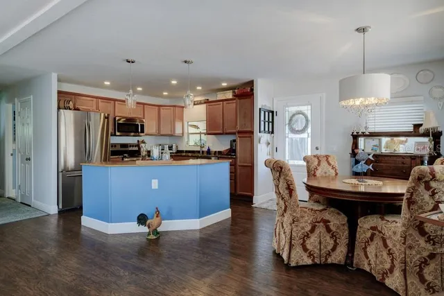 a kitchen with stainless steel appliances kitchen island granite countertop a stove a sink a microwave and wooden cabinets