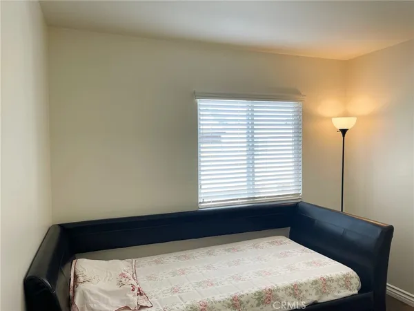 a bed sitting in a bedroom next to a window