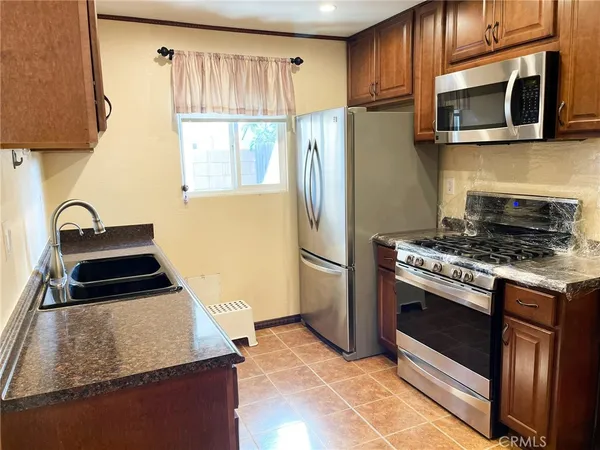 a kitchen with granite countertop a sink stove and refrigerator