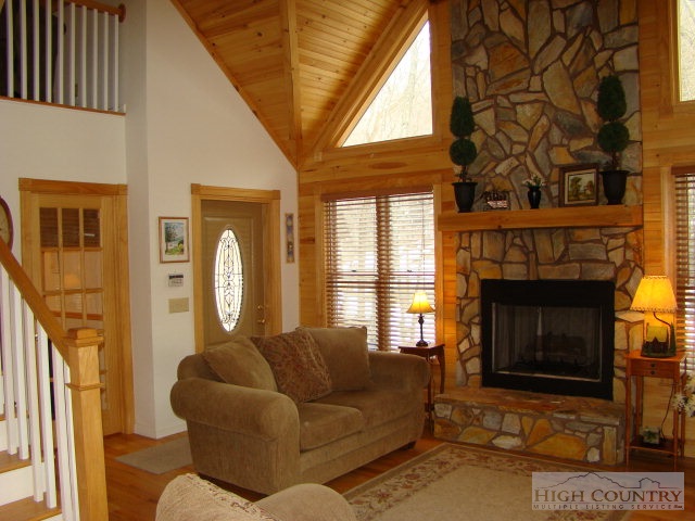 3075 Meat Camp Road Boone, NC 28607 - Photo 11 of 17 a living room with furniture a fireplace and a large window