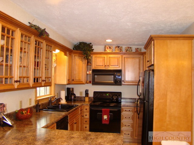 3075 Meat Camp Road Boone, NC 28607 - Photo 12 of 17 a kitchen with stainless steel appliances kitchen island granite countertop a refrigerator and a stove top oven