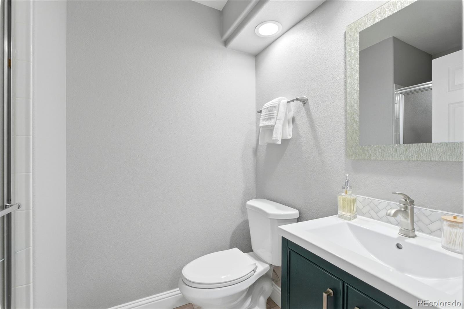 6621 Millstone Place Highlands Ranch, CO 80130 - Photo 22 of 48 a bathroom with a sink a toilet and mirror