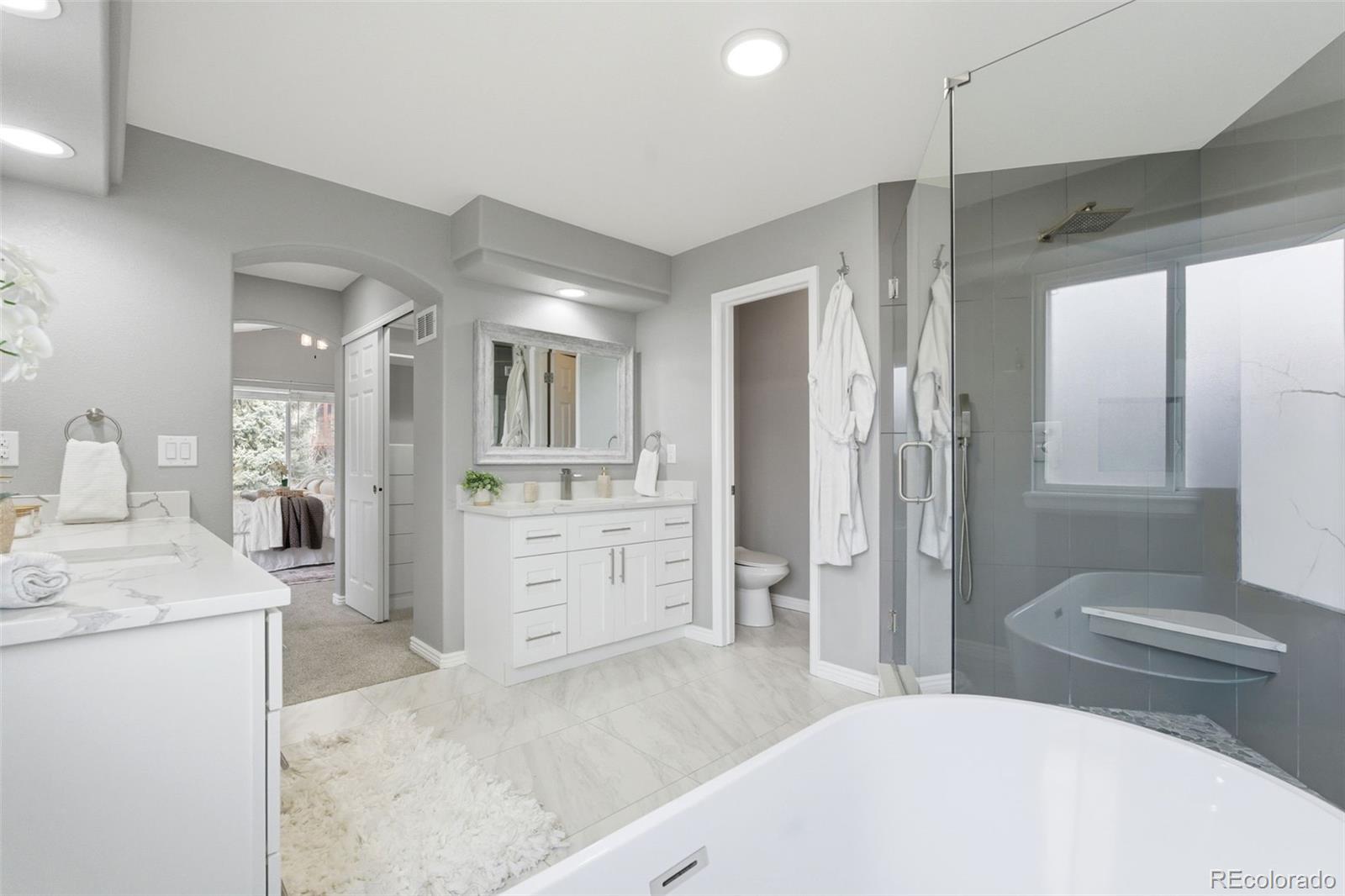 6621 Millstone Place Highlands Ranch, CO 80130 - Photo 30 of 48 a spacious bathroom with a granite countertop sink mirror vanity and toilet