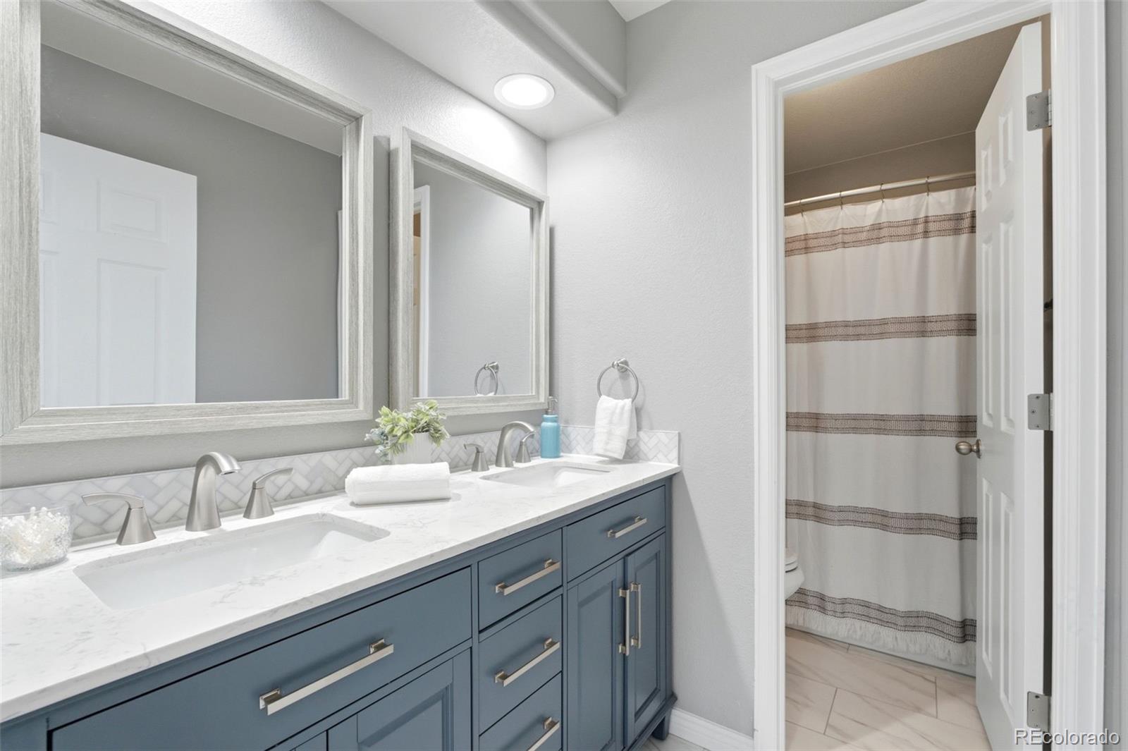 6621 Millstone Place Highlands Ranch, CO 80130 - Photo 36 of 48 a bathroom with a double vanity sink and a mirror