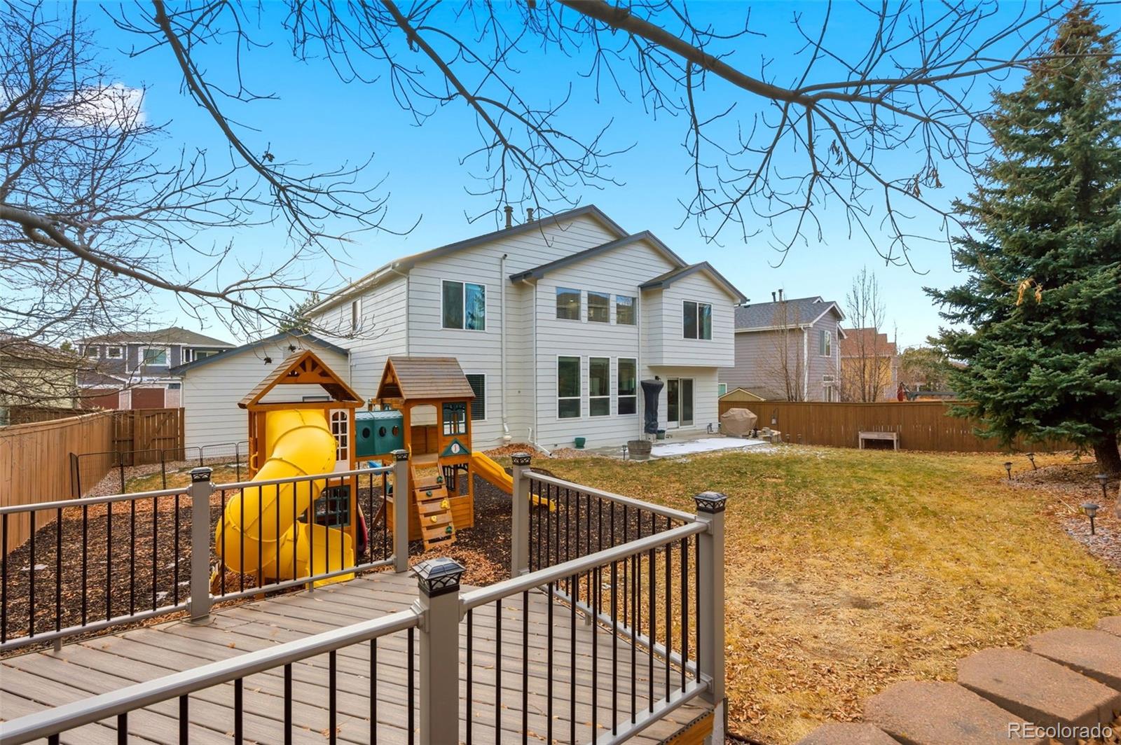 6621 Millstone Place Highlands Ranch, CO 80130 - Photo 44 of 48 a view of a house with large trees and wooden fence
