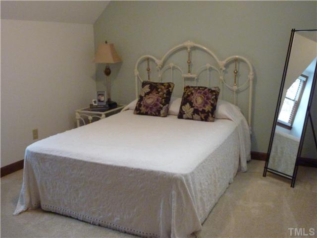 1924 Wilton Circle Raleigh, NC 27615 - Photo 14 of 22 a large bed sitting in a bedroom next to a mirror on dresser and a mirror