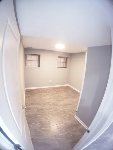 an empty room with wooden floor and mirror
