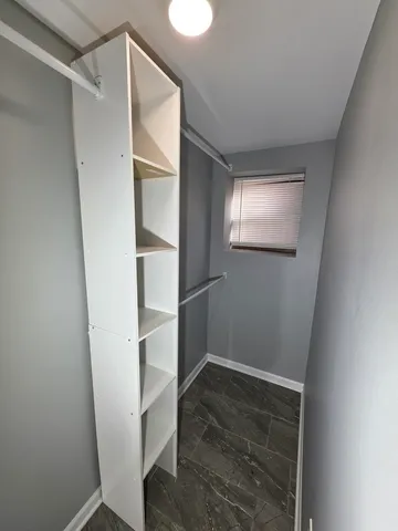 a view of walk in closet with empty racks