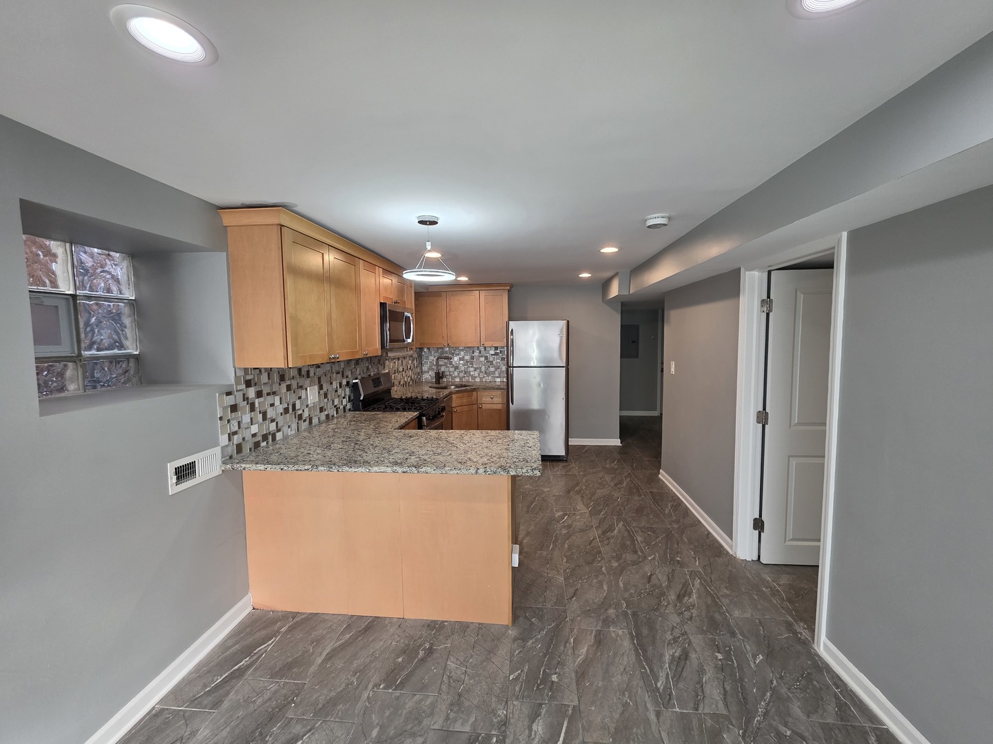 5134 West Henderson Street, Unit G Chicago, IL 60641 - Photo 20 of 47 a view of kitchen with kitchen island a sink wooden floor and a refrigerator