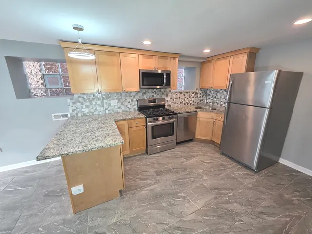 a kitchen with stainless steel appliances granite countertop a sink stove and cabinets