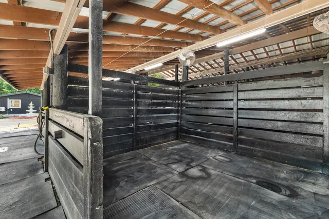 a view of a big building with a big yard and large trees with wooden fence