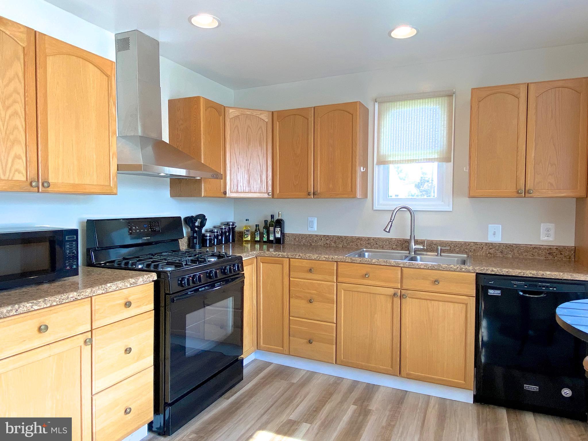 8113 Murray Point Road Dundalk, MD 21222 - Photo 4 of 37 a kitchen with stainless steel appliances granite countertop a stove a sink and a microwave