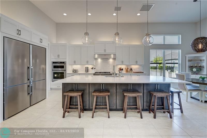 1000 Hookline Circle Loxahatchee, FL 33470 - Photo 11 of 98 a kitchen with stainless steel appliances granite countertop a table chairs sink refrigerator and microwave