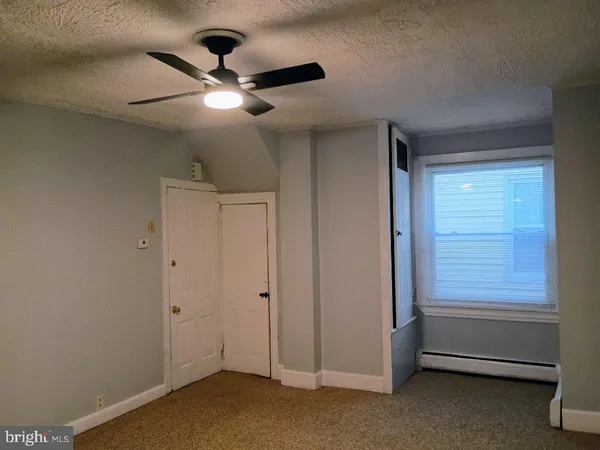 a view of an empty room and a ceiling fan