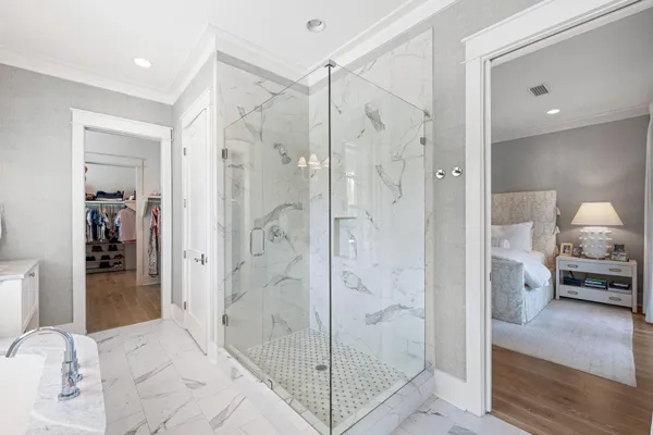 a view of a white house next to a yard with potted plants