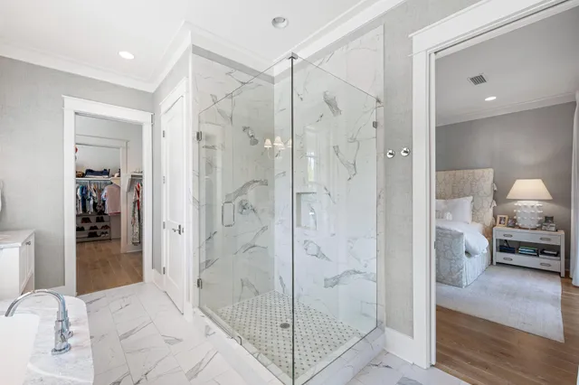 a view of a white house next to a yard with potted plants