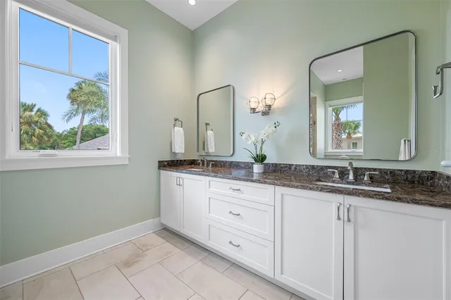a spacious bathroom with a granite countertop sink a toilet and a mirror