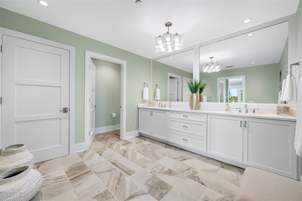 6 Hibiscus Lane Belleair, FL 33756 - Photo 42 of 65 a spacious bathroom with a granite countertop sink a toilet and a mirror
