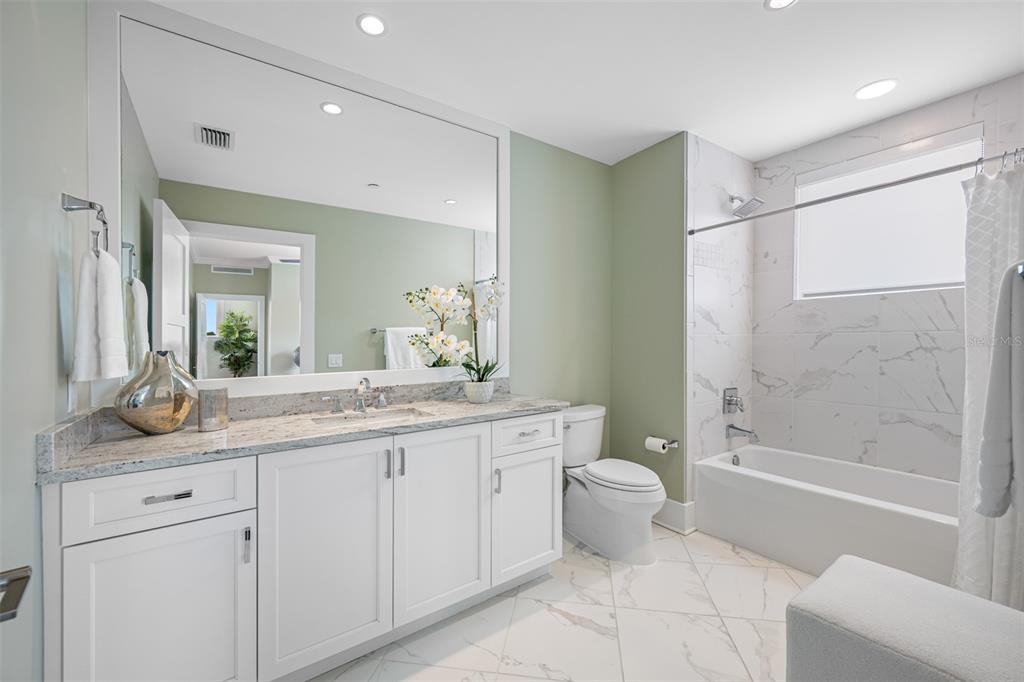 6 Hibiscus Lane Belleair, FL 33756 - Photo 47 of 65 a bathroom with a granite countertop sink a toilet a mirror and shower