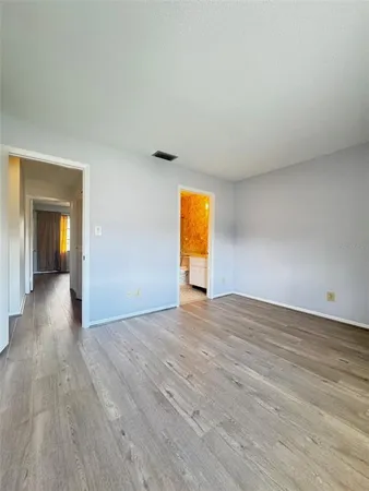 a view of empty room with wooden floor
