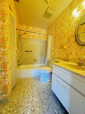 a bathroom with a granite countertop bathtub sink and toilet