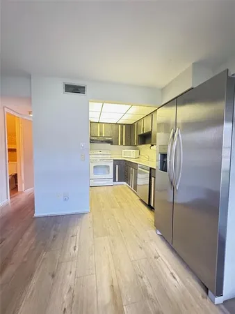 a kitchen with kitchen island a counter top space a sink and a refrigerator