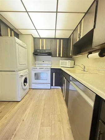 a kitchen with stainless steel appliances granite countertop a sink a stove and a refrigerator